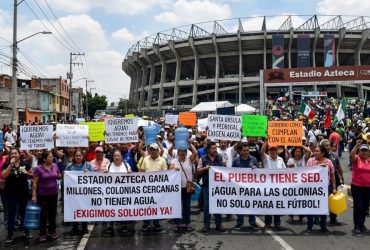 A los habitantes de la colonia Pedregal de Santa Úrsula, junto al estadio Azteca, no les han hecho justicia cuatro Mundiales de Futbol, ni los gobiernos del Partido Revolucionario Institucional, Partido de la Revolución Democrática, ni el Movimiento de Regeneración Nacional. Sus problemas de escasez de agua persisten. IMAGEN: Recreación de protestas en el Estadio Azteca con inteligencia artificial de Gemini